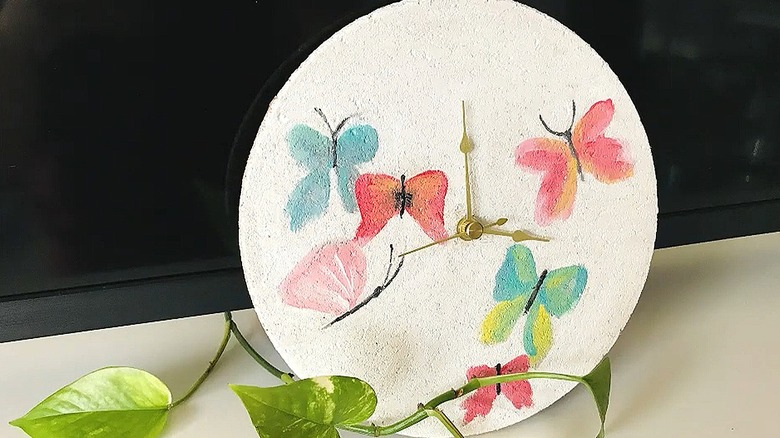 Butterflies painted on a cork trivet with a clock movement placed in the center