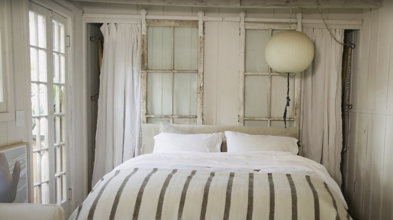 Distressed white closet doors behind bed