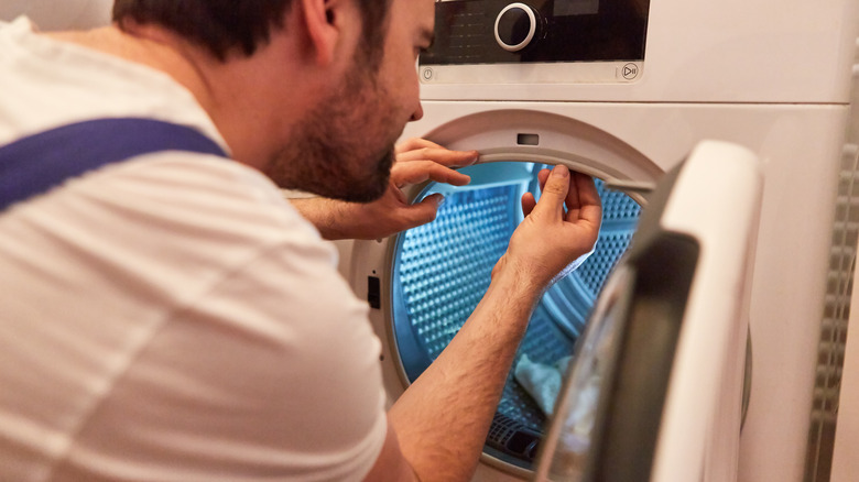 man fixing broken dryer seal