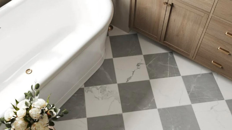 black and white diagonal checkered bathroom floor with bathtub and counter in corner
