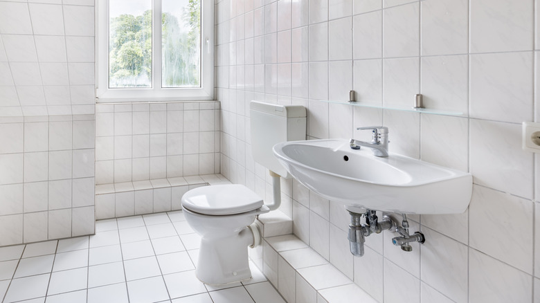 bathroom with white square tiles across walls and floor