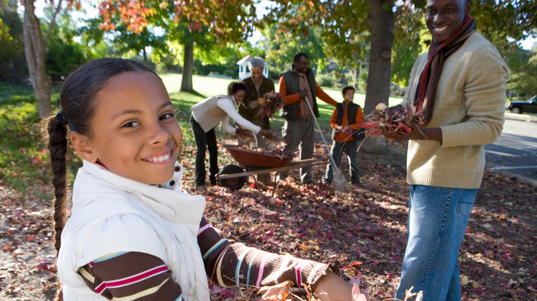 Family raking leaves together