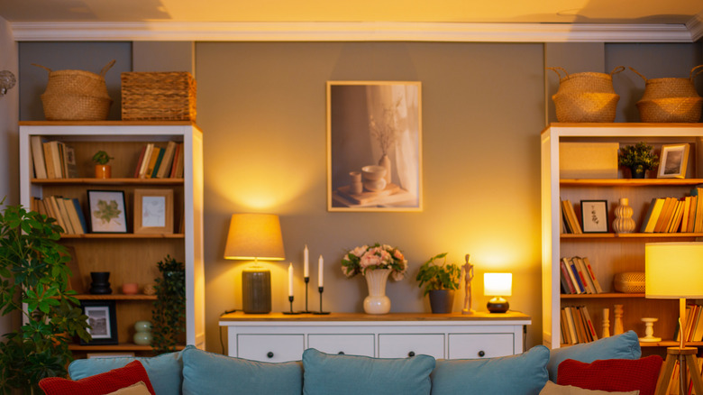 A living room with many warm-toned lamps switched on