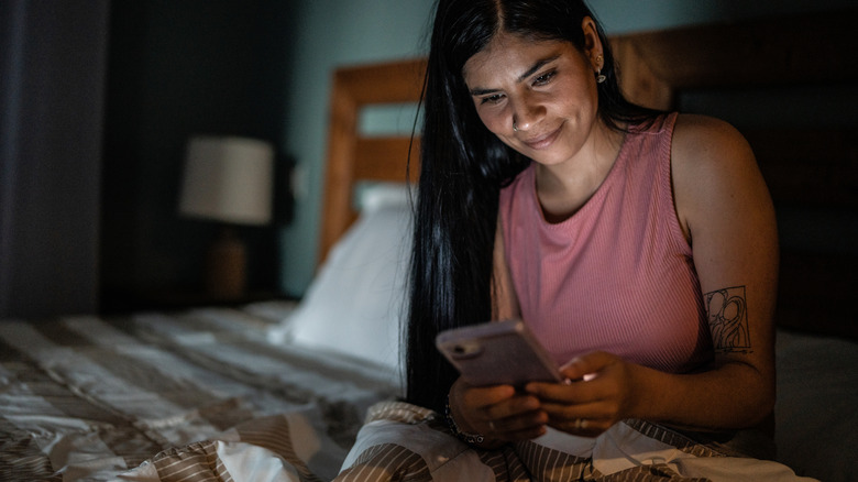 A man's phone is sending him an alert, symbolized by a glowing red caution sign
