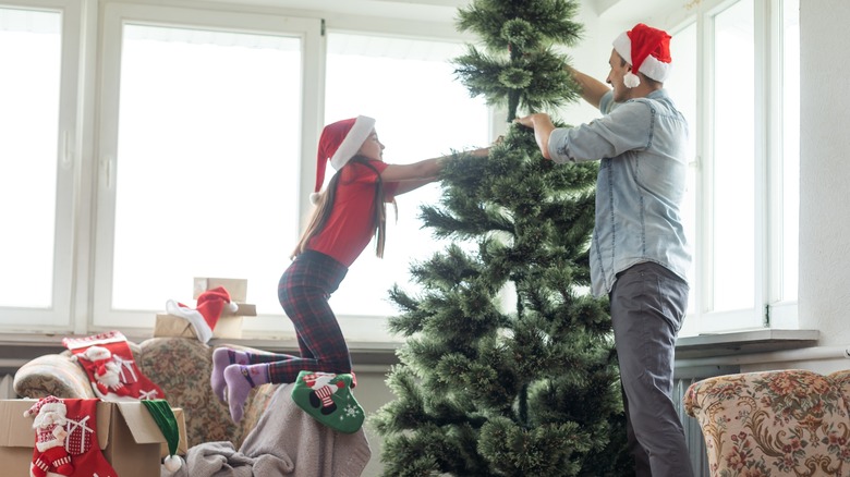 People setting up artificial Christmas tree