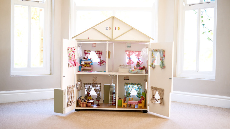 Large doll house with hinged walls that open in an empty room