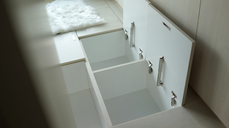 hidden in-floor storage boxes with hinged tile doors