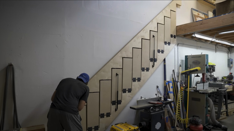 Man working on hinged fold up ladder in a workshop