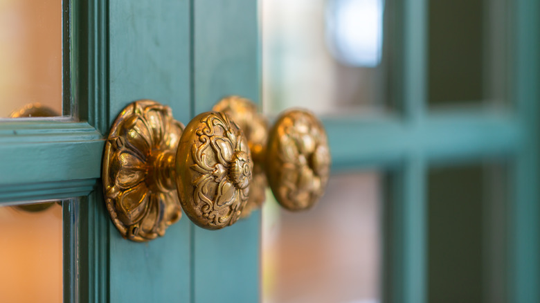 Antique door knobs on green door