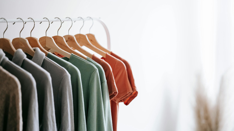 Duplicate polos and business casual shirts in multiple colors hanging on white rack