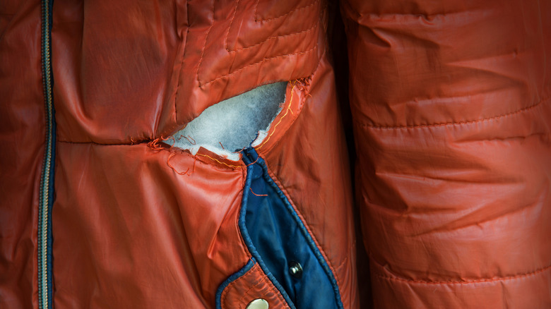 ripped puffy red orange jacket pocket exposing filler