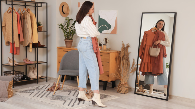 young woman trying on cottagecore outfit in mirror