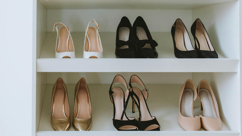 Collection of pointed open and closed-toe heels on white closet shelves