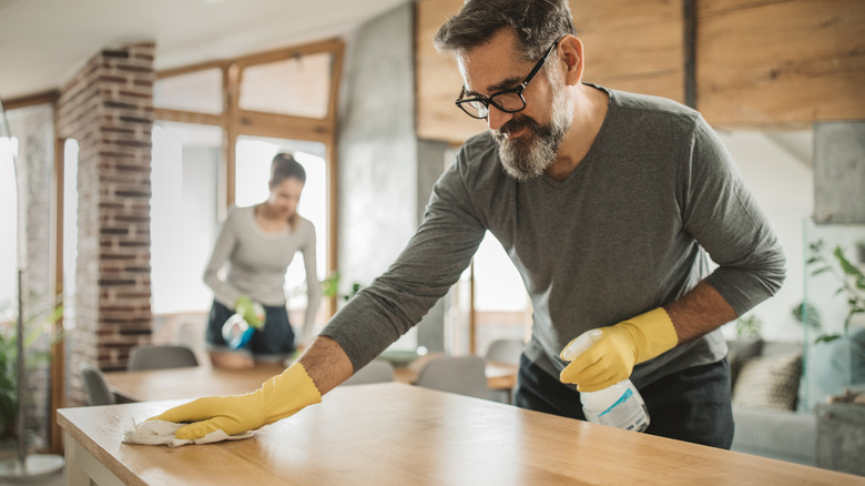 bearded man cleaning countertop
