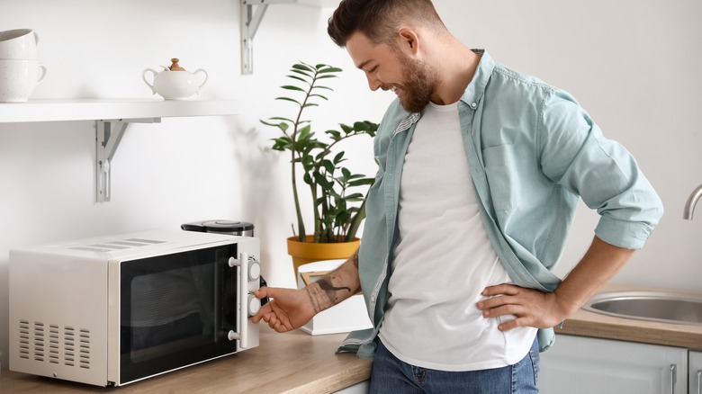 young man using microwave