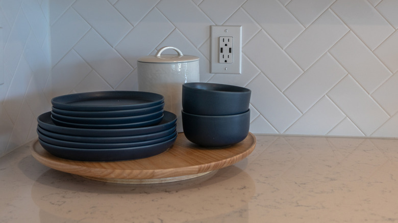A lazy Susan holding bowls and cups in a dark blue color.