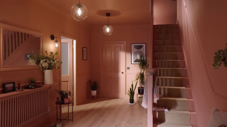 A home entry way and staircase with pink walls and ceiling