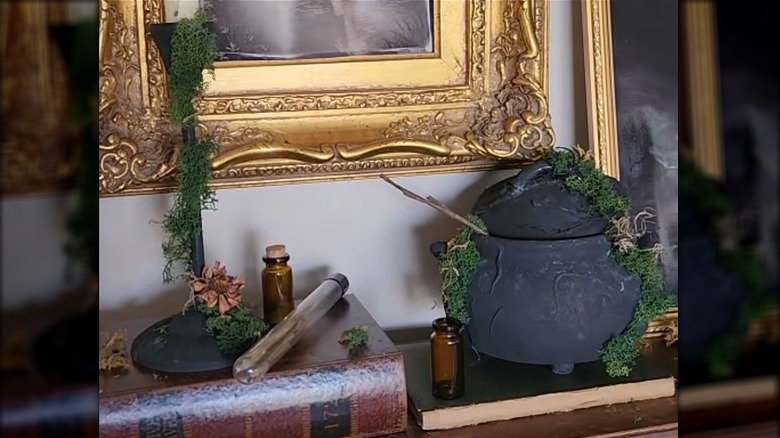 A Dollar Tree cauldron, book and candlestick are made creepy with paint and glue.