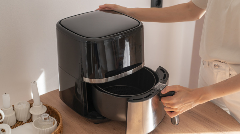 Person opening an air fryer drawer