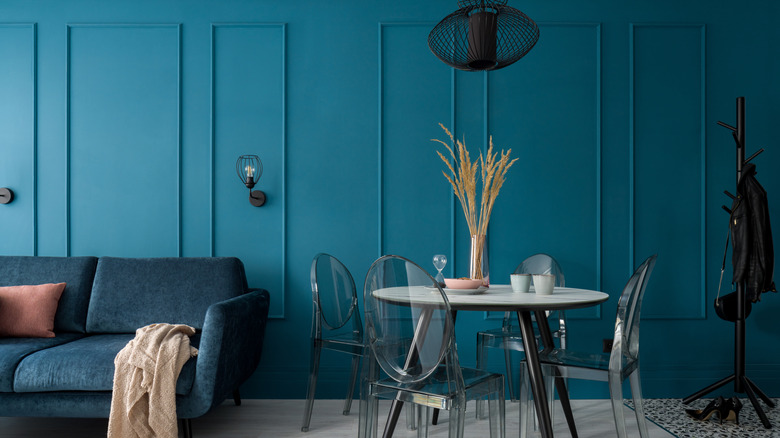 Walls and panel molding in a living space painted a jewel-toned teal