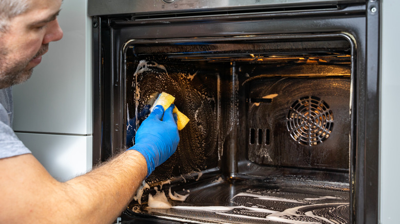 Man cleaning oven