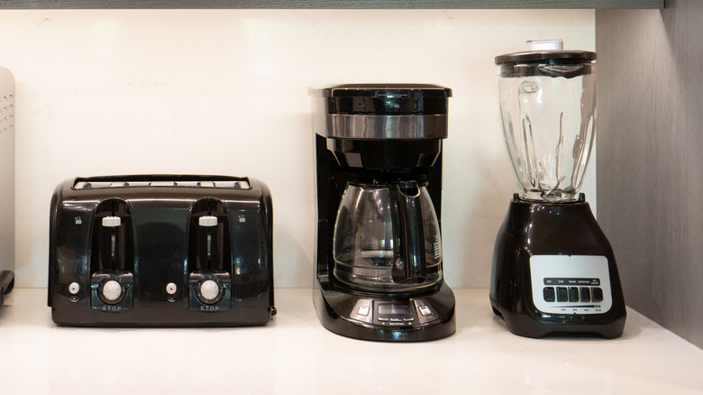 Toaster, coffee maker, and blender on kitchen countertop.