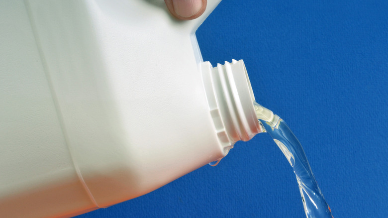 person pouring bleach