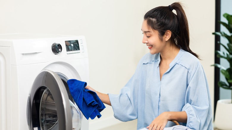 Woman putting towel in washer