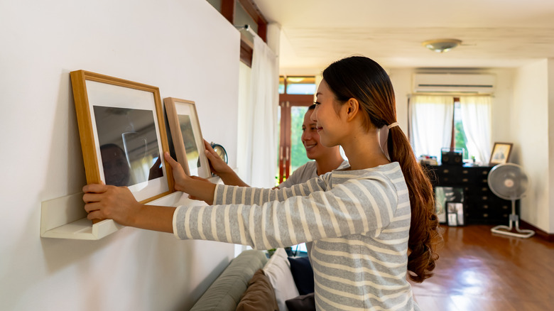 Woman hanging artwork