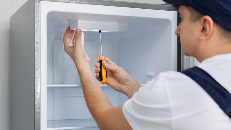Man repairing interior of a refrigerator