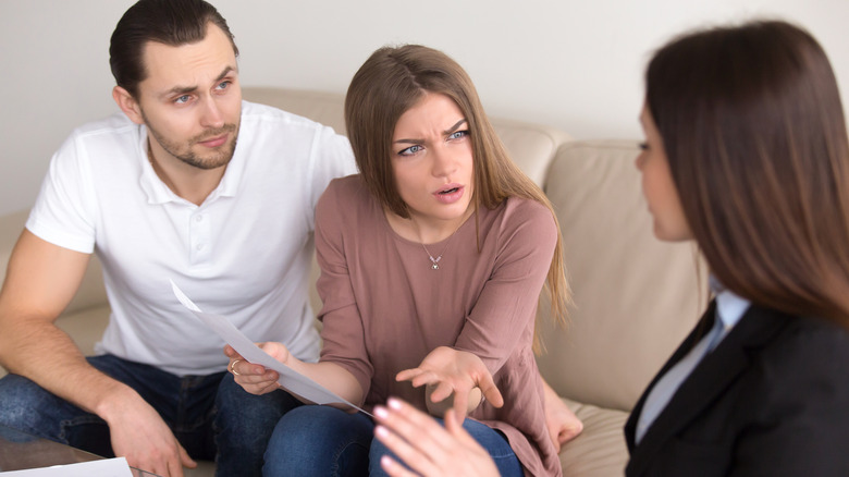 People in conversation, looking upset