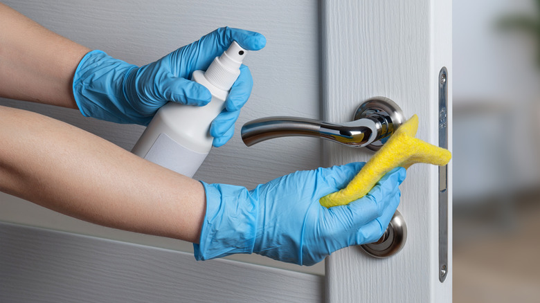 person cleaning door handle
