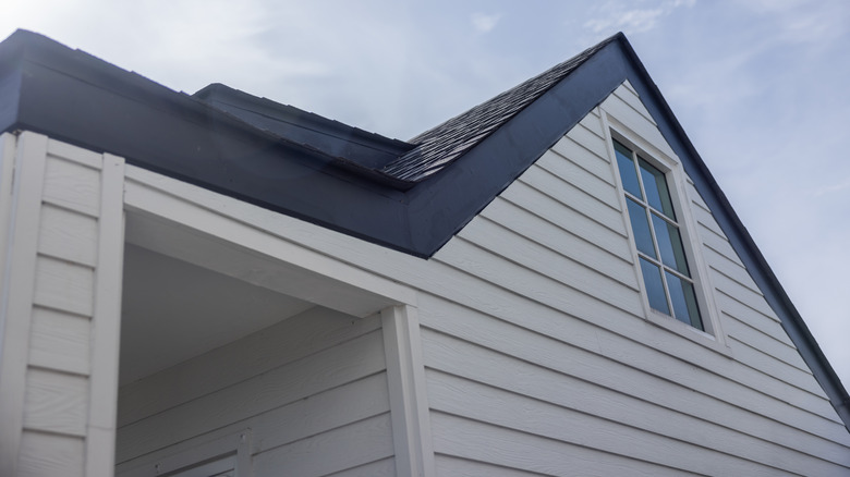 A house with white siding and black roof.