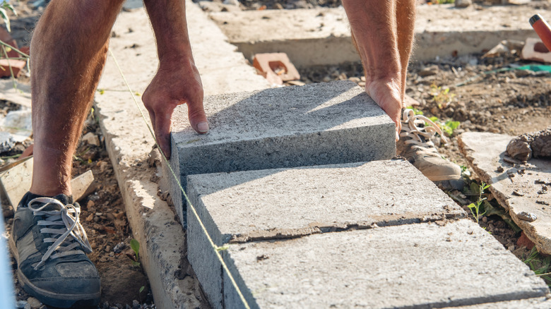 Someone stacking concrete blocks