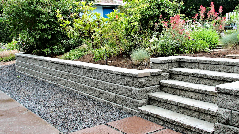 Concrete blocks form a retaining wall to hold back soil.