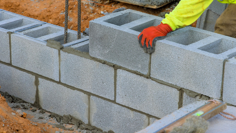 Worker lays cement blocks on job site