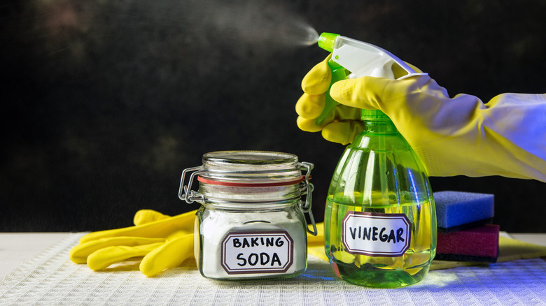 A jar of baking soda and a spray bottle of vinegar