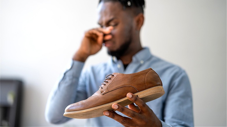 Person holding smelly shoe