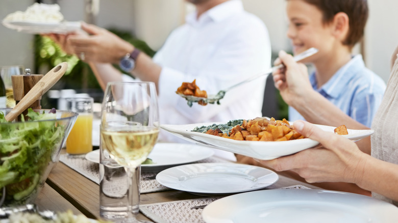 Family eating off of white dishes