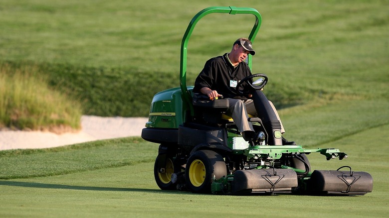 Close up of person on a riding lawn mower