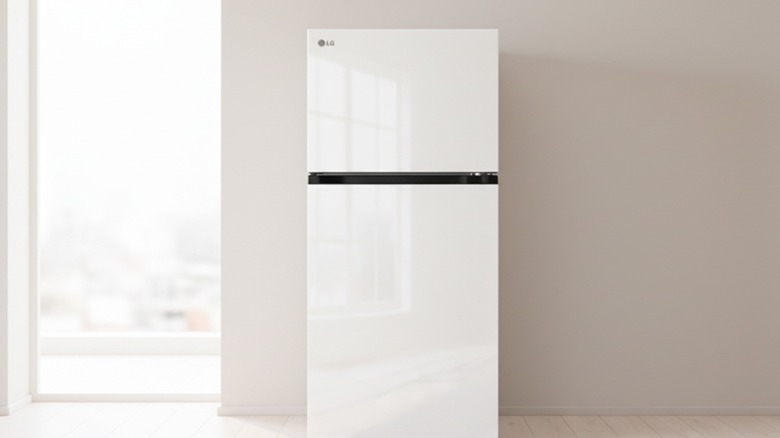 An LG top-freezer refrigerator is set up in a room against a neutral-colored wall.