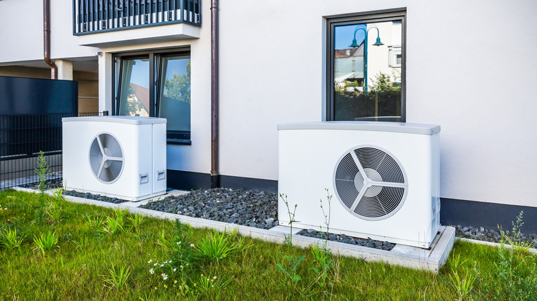 Two air source heat pumps installed outside of new and modern city house