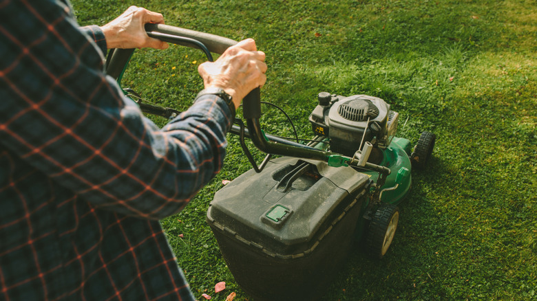 A person cutting grass with a John Deere mower