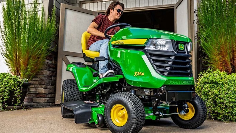Man riding John Deere X354 lawn mower