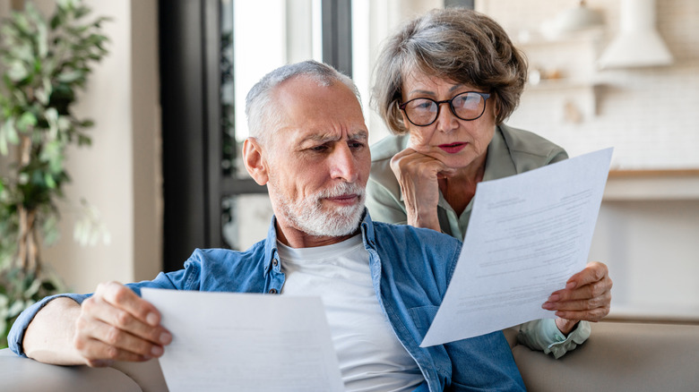 A bewildered couple looks at an insurance bill