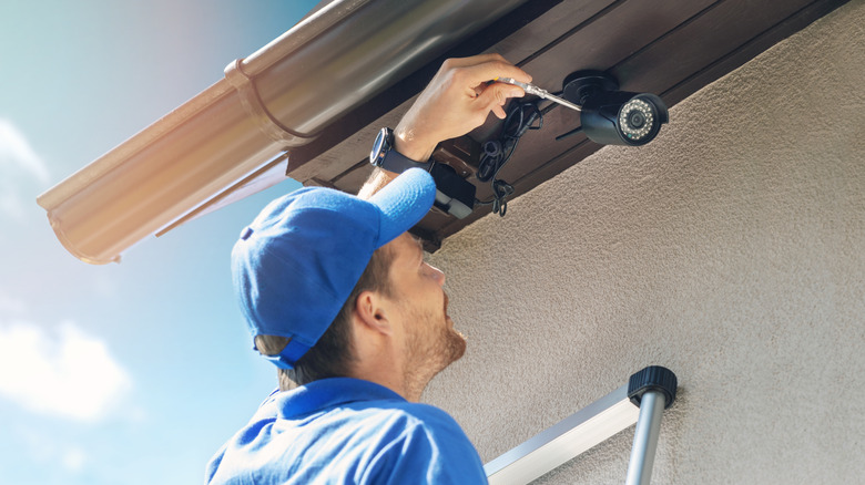 a man installing an outdoor security camera