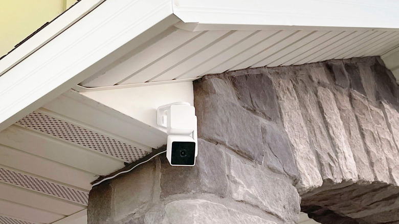 a wyze cam v3 pro sits at the eave end of a house to provide front door security