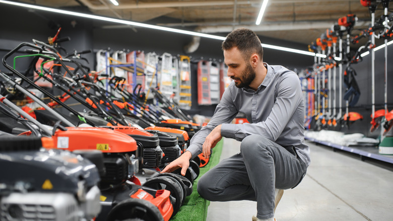 A man in a store viewing lawnmowers