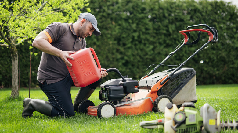 A man refueling his lawnmower with gas