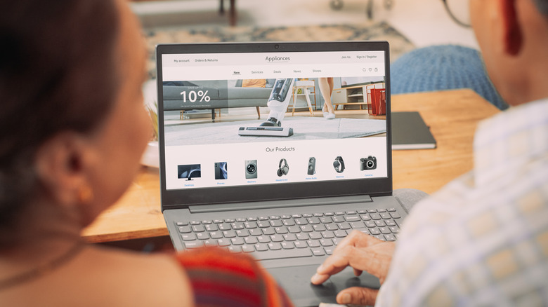 A couple is using a laptop to buy appliances online